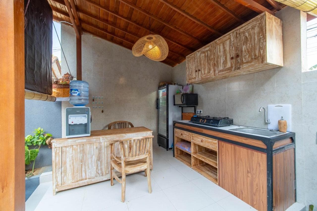 a kitchen with wooden cabinets and a counter top at Skyline Sanur by Manara in Sanur