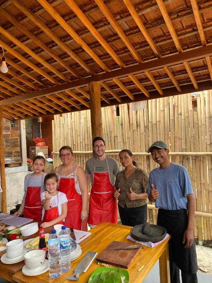 a group of people standing in front of a table at Dewi Teduh Villa in Sidemen