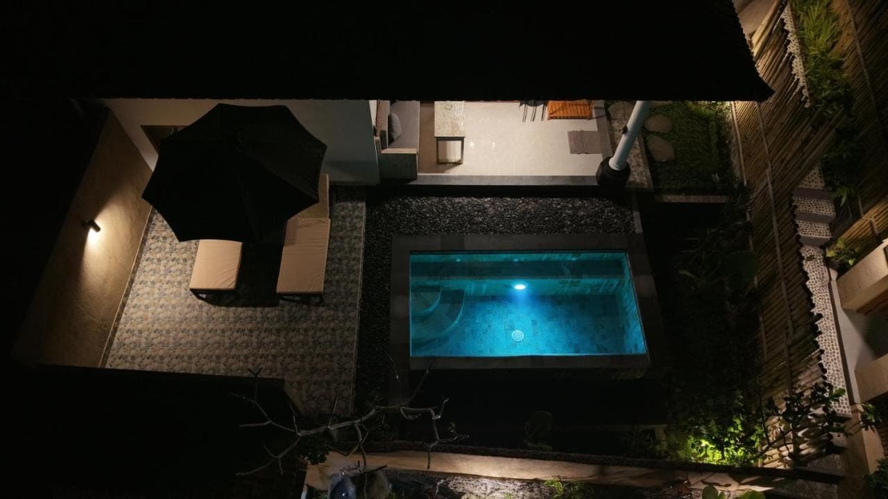 an overhead view of a swimming pool with an umbrella at Dewi Teduh Villa in Sidemen