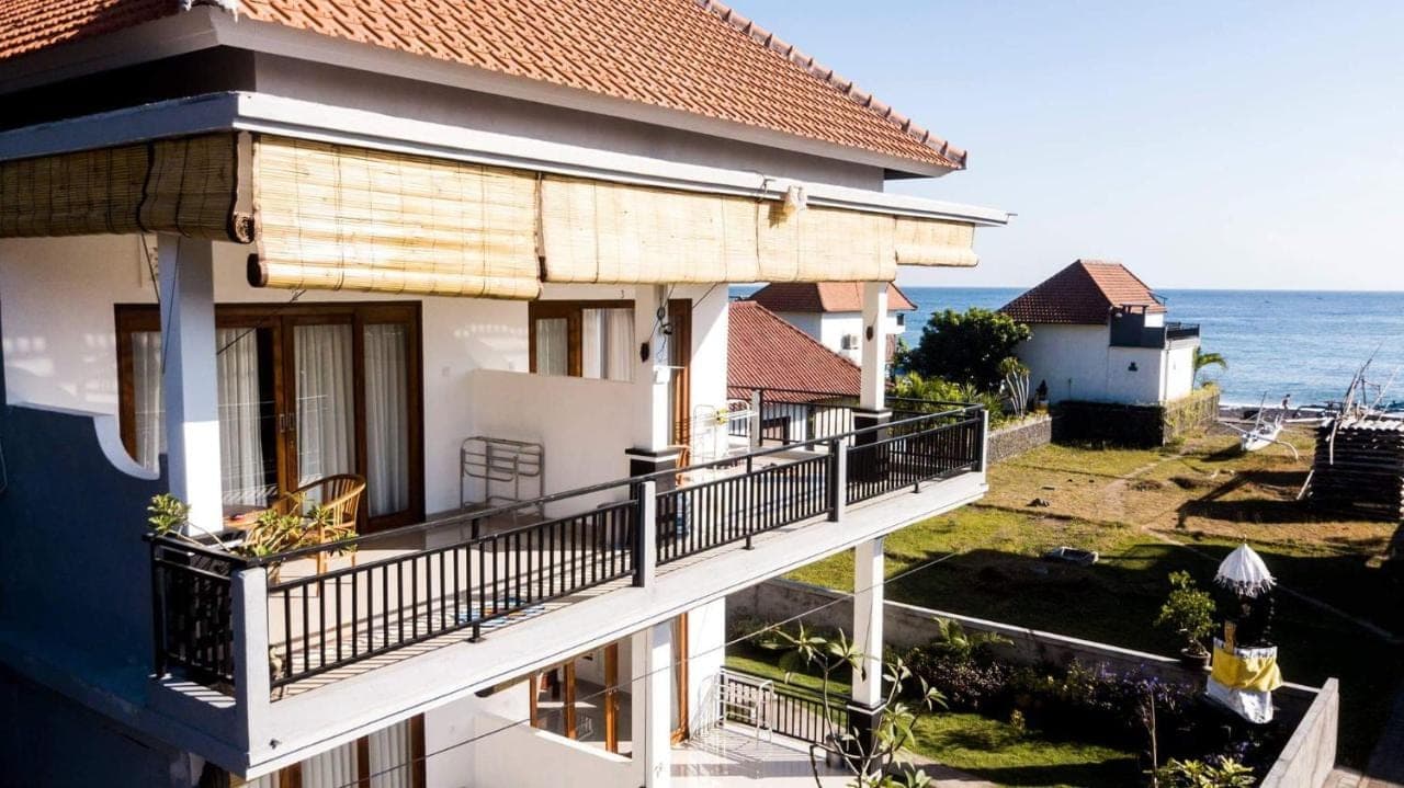 a building with a balcony overlooking the ocean at Minory Guesthouse in Amed