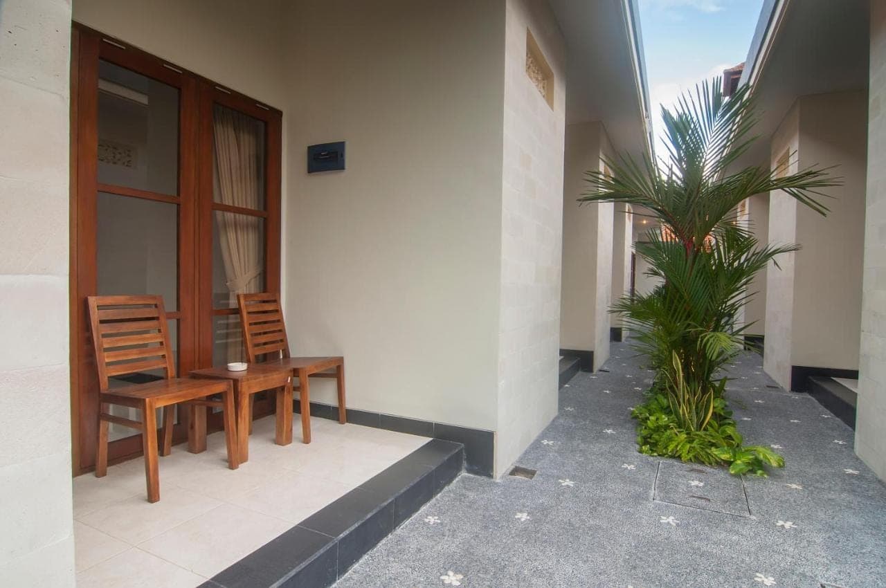 a patio with two chairs and a table on a building at Duyung Homestay in Sanur
