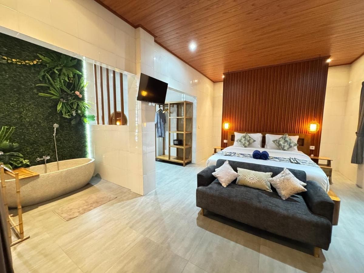 a bedroom with a bed and a tub and a couch at Ayu Homestay in Ubud