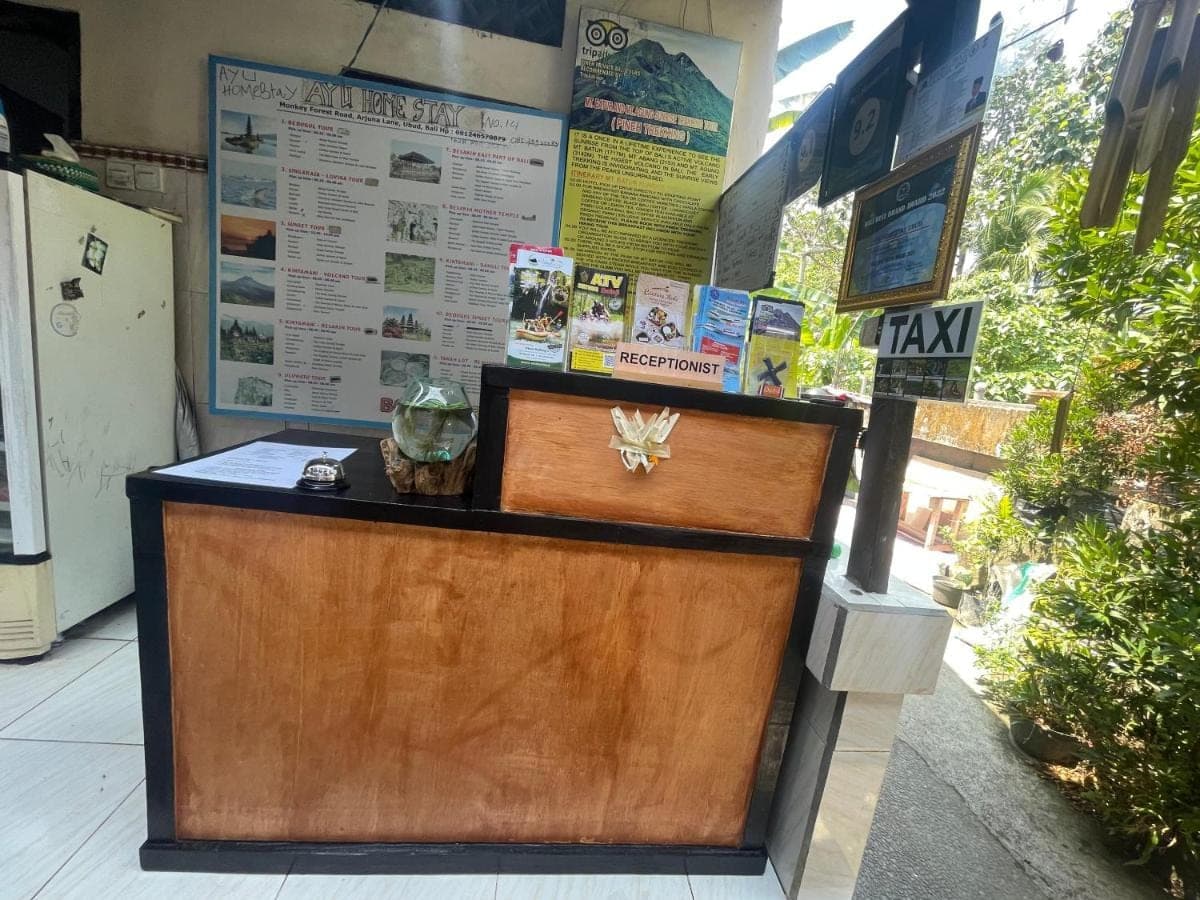 a front desk of a restaurant with a wooden door at Ayu Homestay in Ubud
