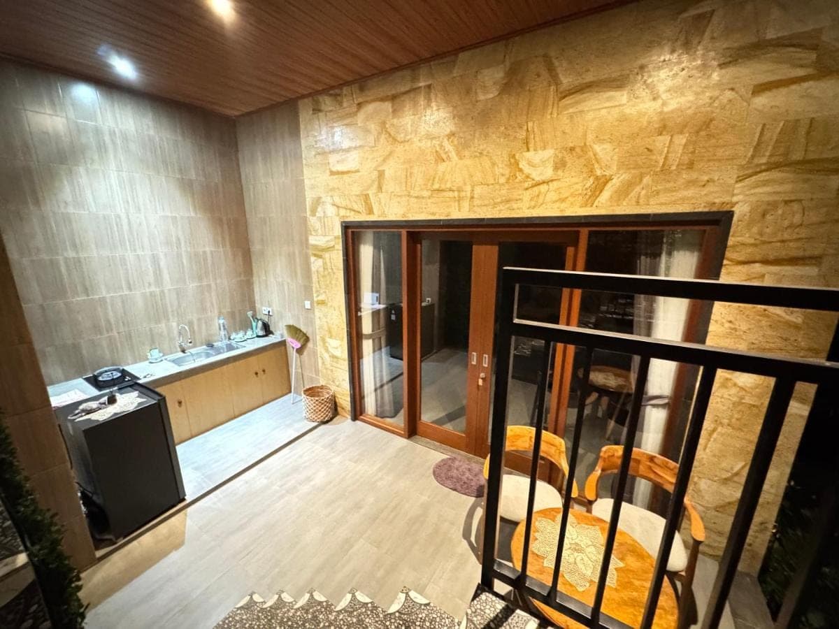 an empty room with a kitchen and a television at Ayu Homestay in Ubud