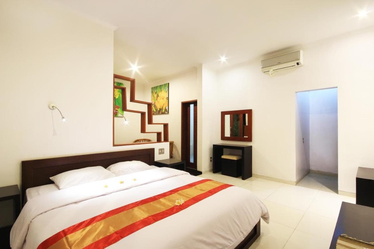 a bedroom with a large bed in a room at Letos Kubu Homestay in Kuta
