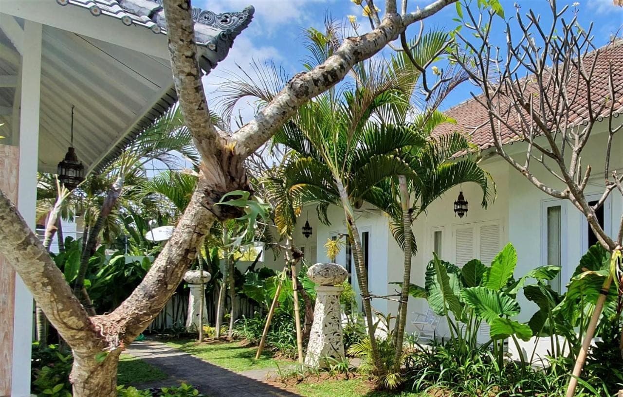 a white house with trees in front of it at Starling villas in Sanur