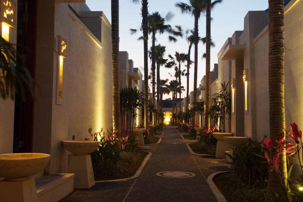 an empty street with palm trees and buildings at Daluman Villas in Seminyak