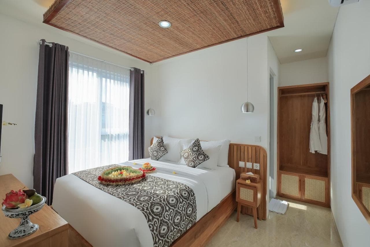 a bedroom with a bed with a bowl of fruit on it at Opin Villa in Nusa Dua