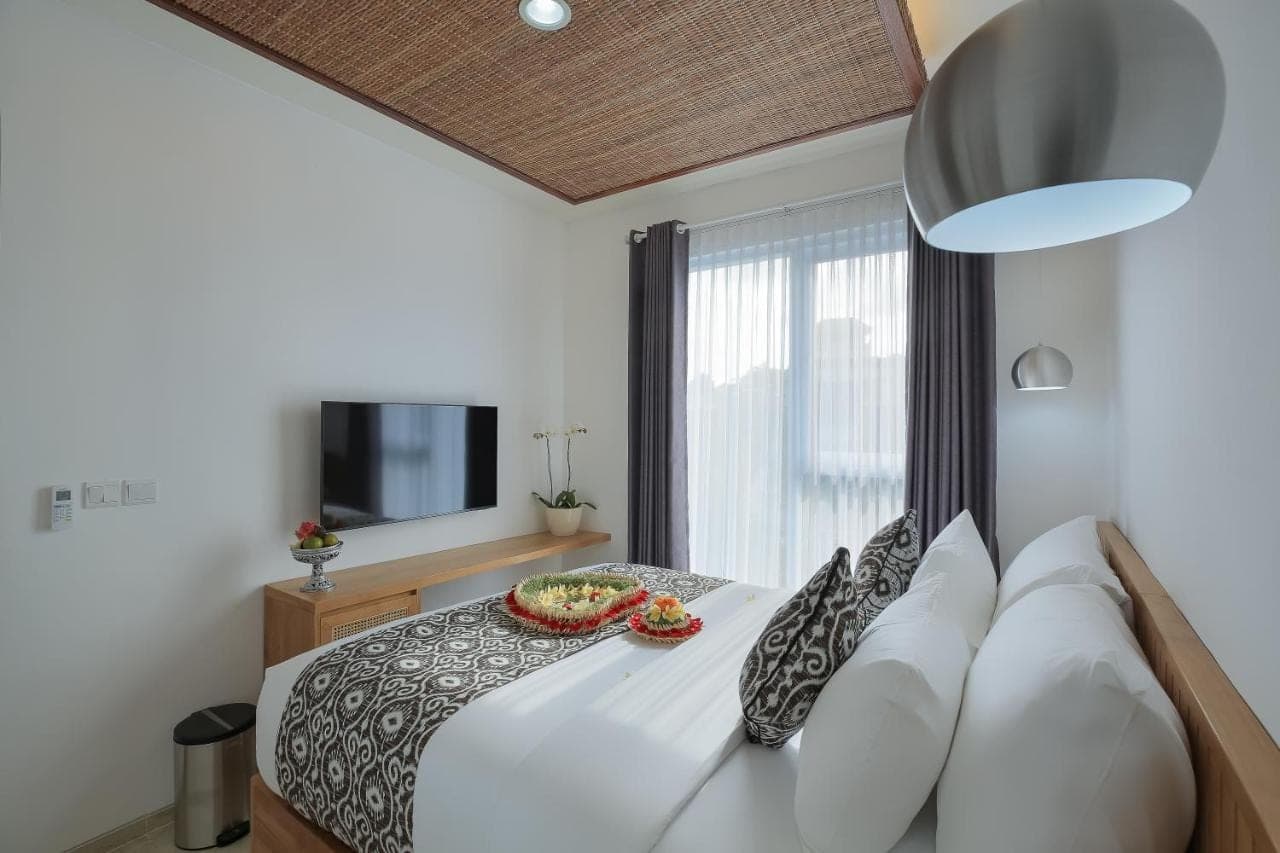 a large white bed with a bowl of fruit on it at Opin Villa in Nusa Dua