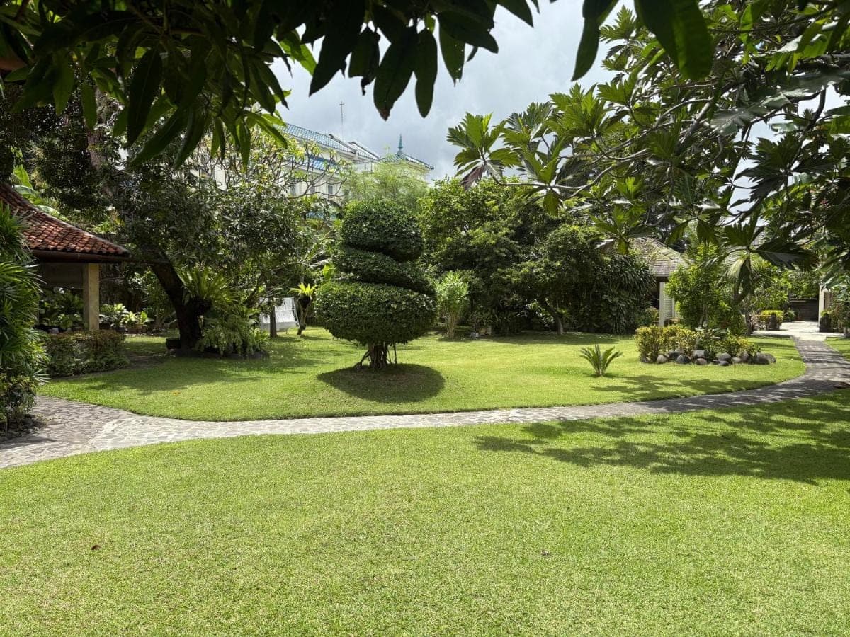 a park with a sculpture in the grass at Raja Gardens Hotel in Seminyak