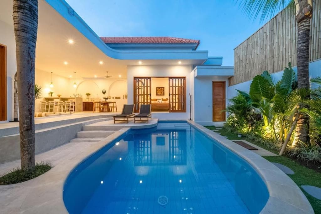 a swimming pool in a villa with a house at Villa TOLOSA - Modern 3BR - Central Canggu Beach in Canggu