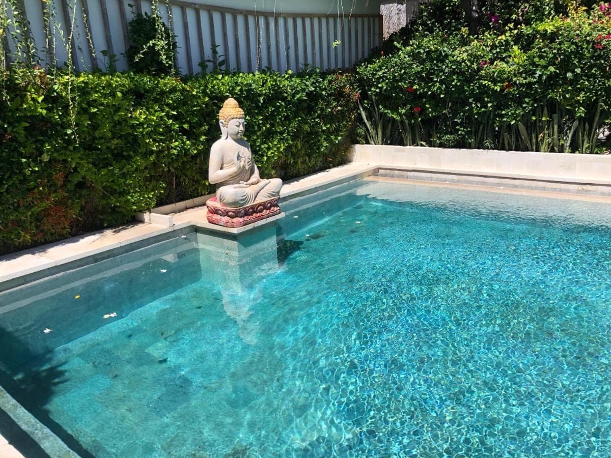a small pool with a statue in the water at Meditasi Bungalows &amp; Villas in Amed