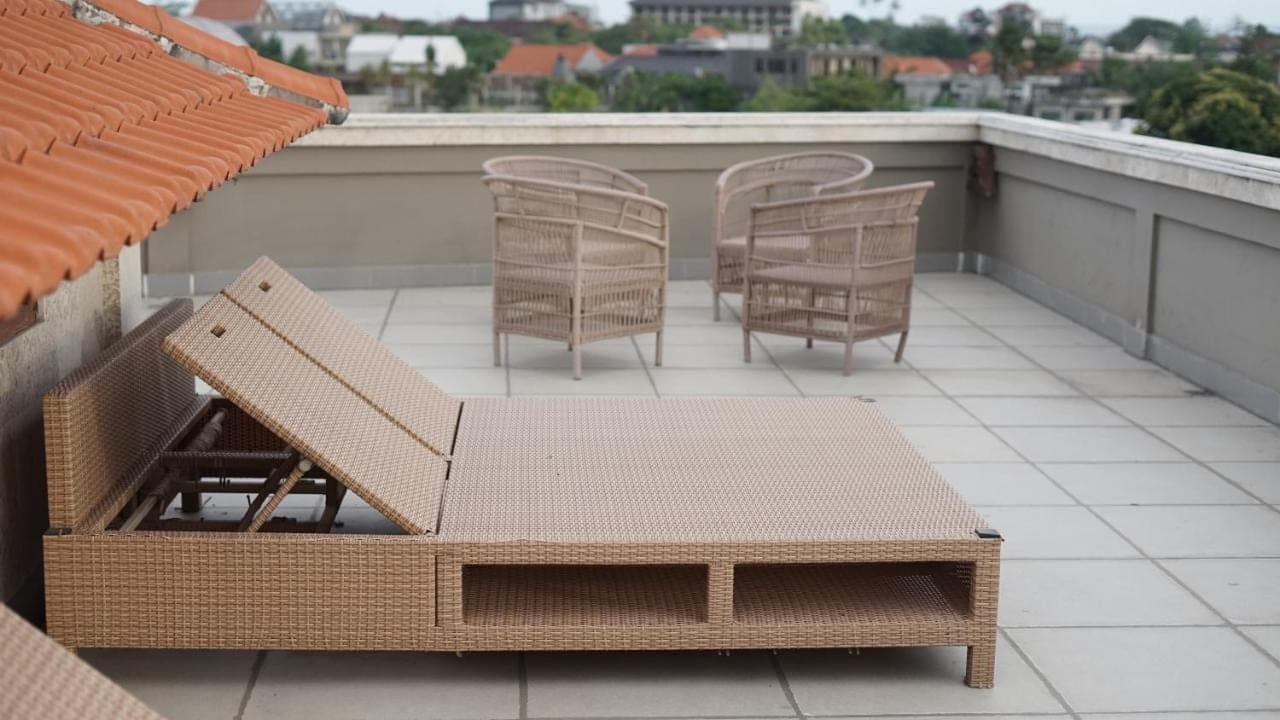 a patio with chairs and a table on a roof at Alu Lofts in Seminyak
