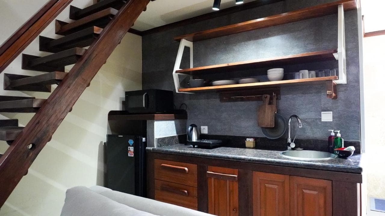 a kitchen with a sink and a black refrigerator at Alu Lofts in Seminyak