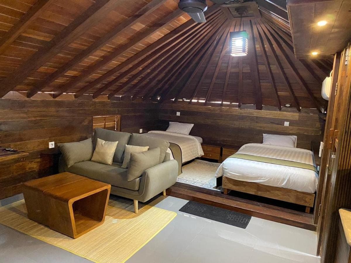 a bedroom with two beds and a couch in a room at Alu Lofts in Seminyak