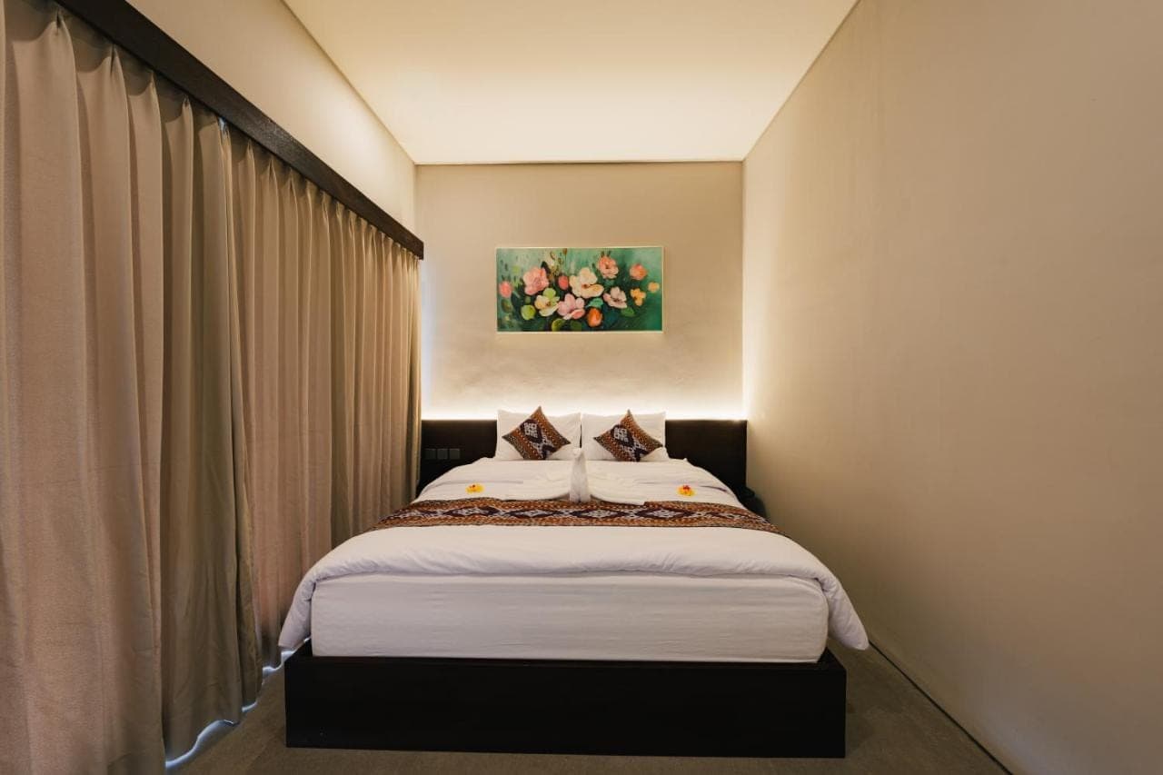 a bedroom with a bed in a room at Kuma House in Ubud