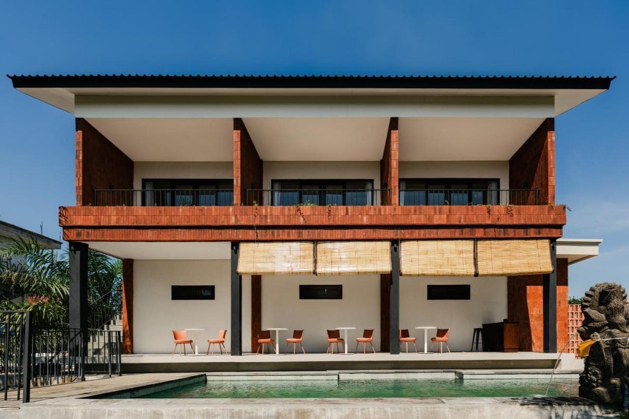 aominium building with a balcony and chairs at Kuma House in Ubud