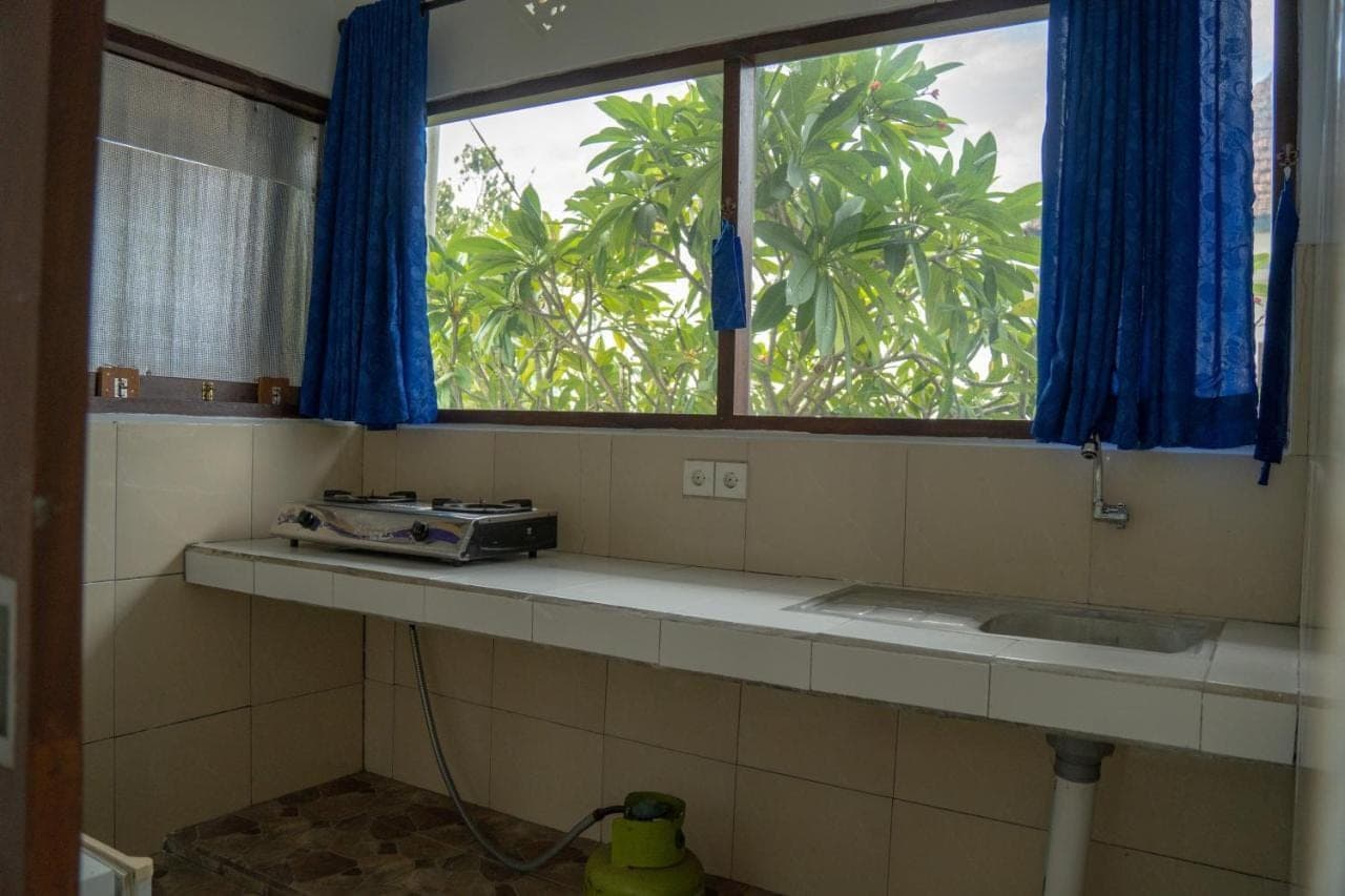 a window in a bathroom with a sink and a window at Pakel's Bali Villas in Amed