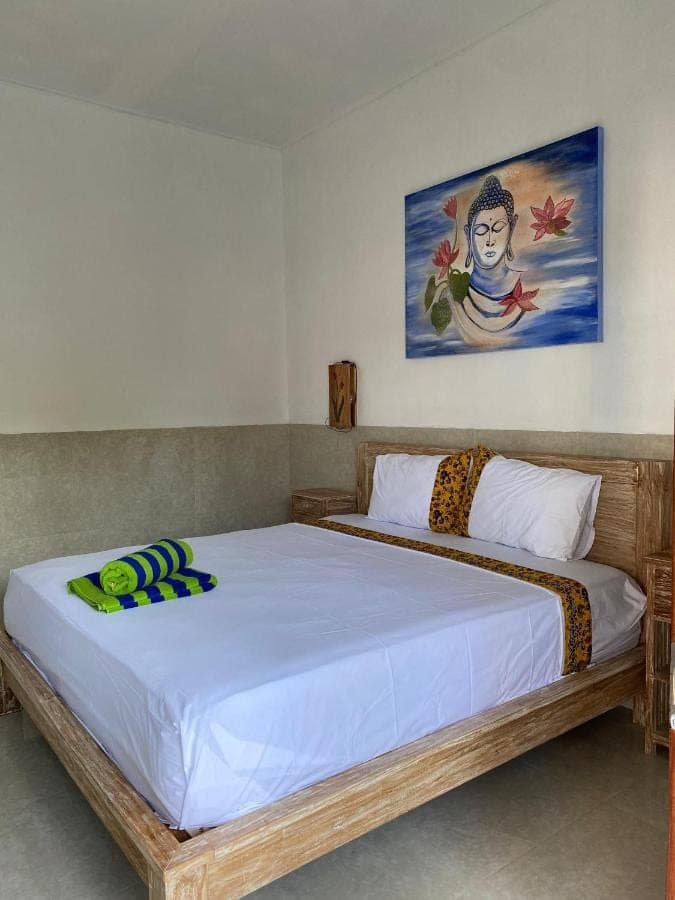 a bedroom with a large bed in a room at COCONUT BEACH BUNGALOWs &amp; WARUNG 2 in Amed