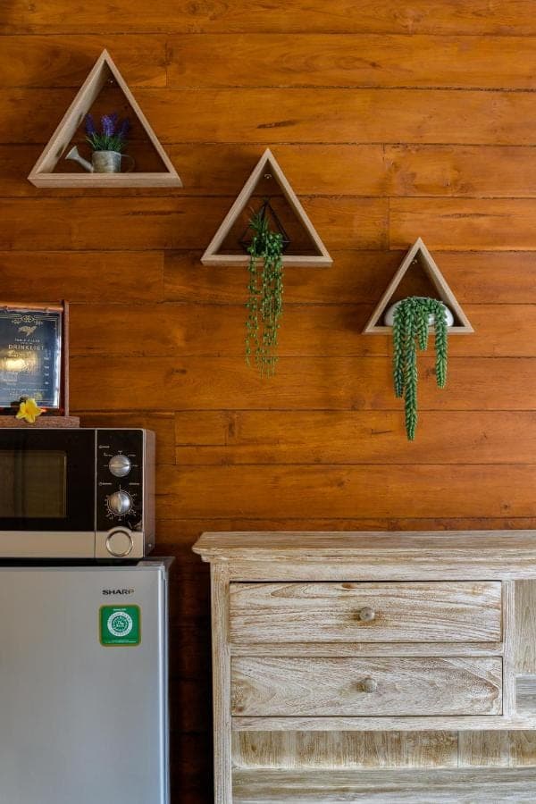 a kitchen with a wooden wall with plants on it at Turtle Villas, Canggu by Manara in Canggu
