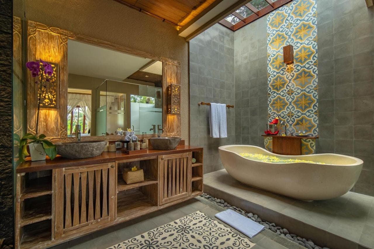 a bathroom with two sinks and a tub and a mirror at Bliss Ubud Spa Resort in Ubud