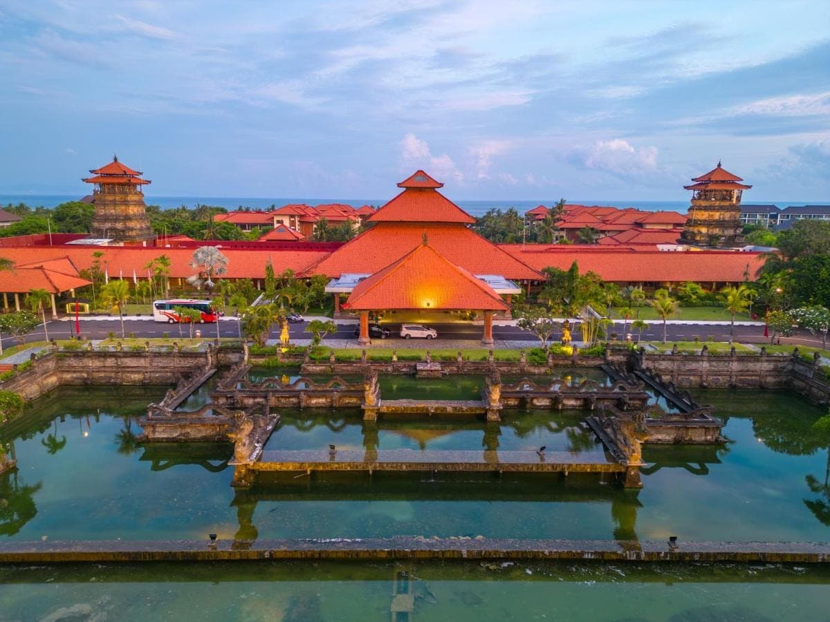 a building with red roofs and a pool of water at Ayodya Resort Bali in Nusa Dua