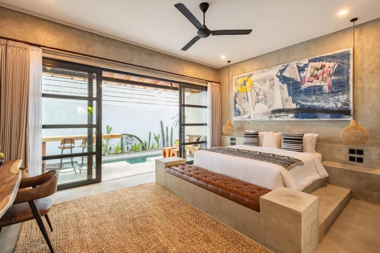 a bedroom with a large bed and a large window at Ubud Lila Concept in Ubud