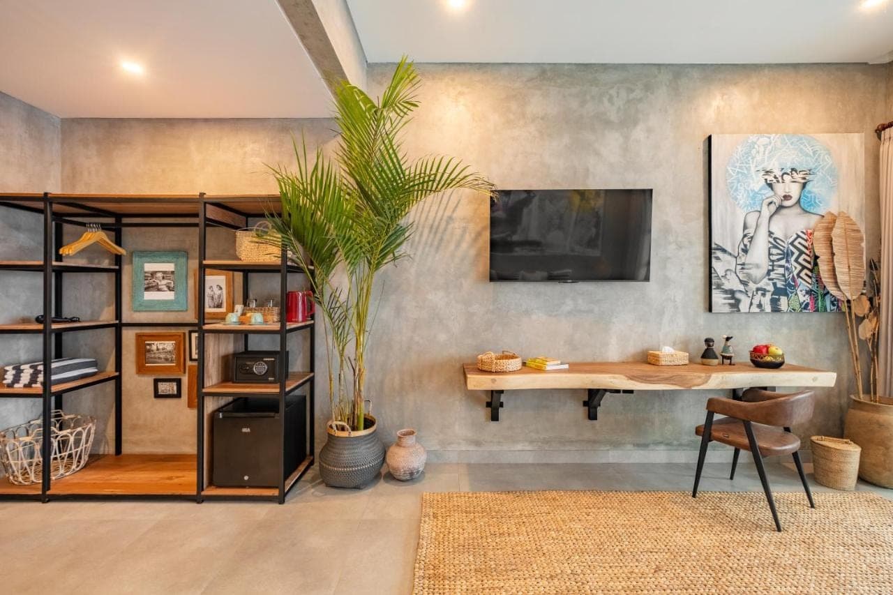 a room with a desk and a tv on a wall at Ubud Lila Concept in Ubud