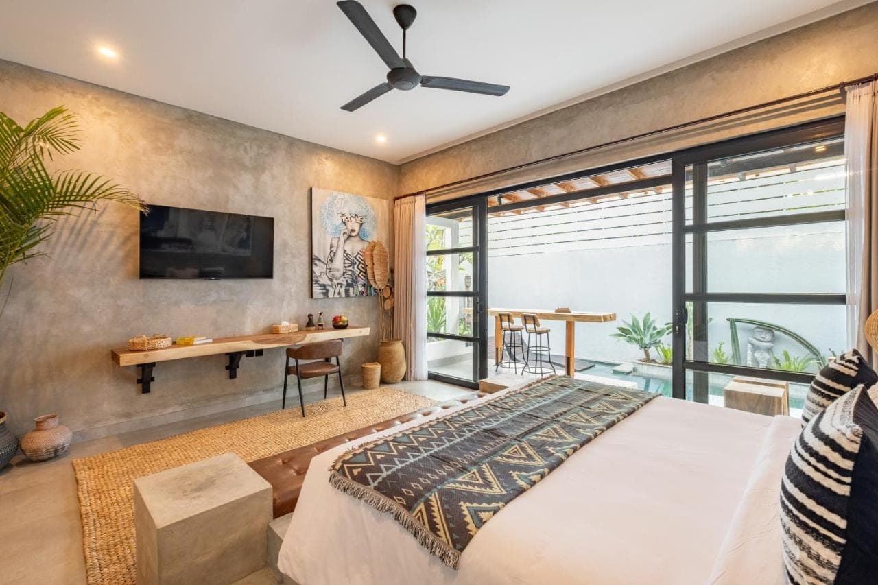 a bedroom with a bed and a desk at Ubud Lila Concept in Ubud