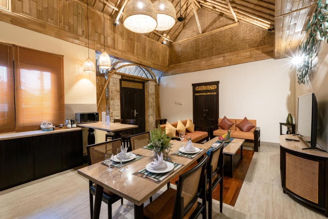 a living room with a table and a couch at Bali Sunshine Nusa Dua in Nusa Dua