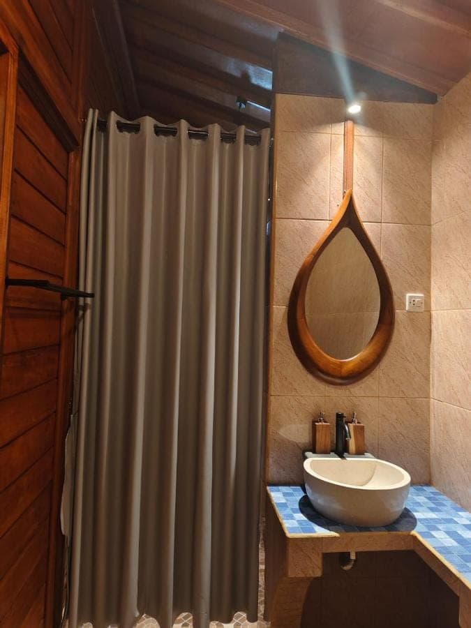 a bathroom with a sink and a shower curtain at Bukit Luah Sidemen in Sidemen