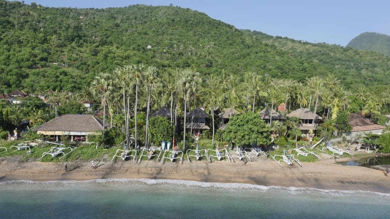 an aerial view of a resort with chairs on the beach at Coral View Villas in Amed