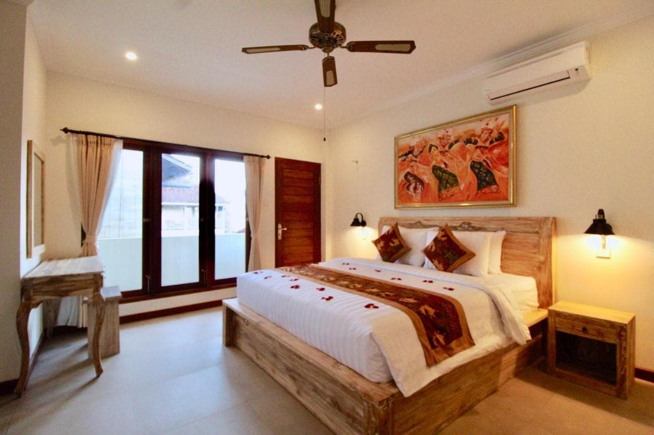 a bedroom with a large bed and a window at Pacha House in Ubud