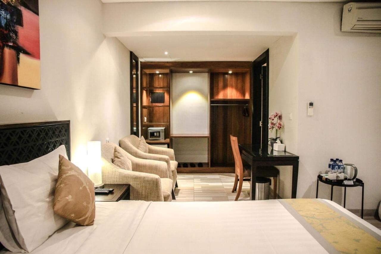 a bedroom with a bed and a living room at Dekuta in Kuta