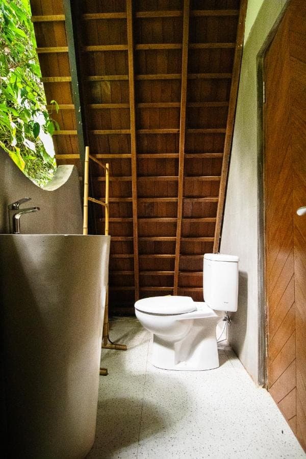 a bathroom with a toilet and a sink at Natya River Sidemen in Sidemen