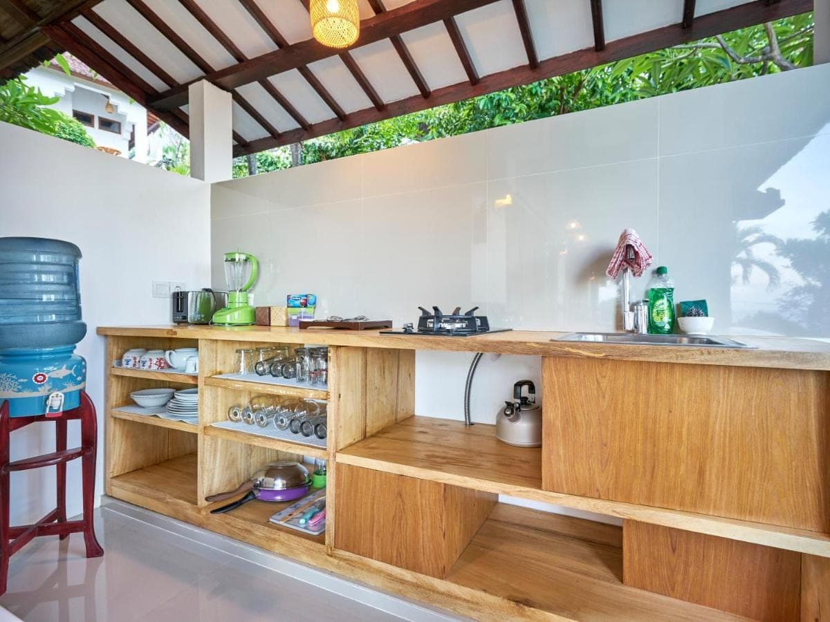 a kitchen with a wooden counter and a sink at Anda Amed Villas &amp; Spa in Amed