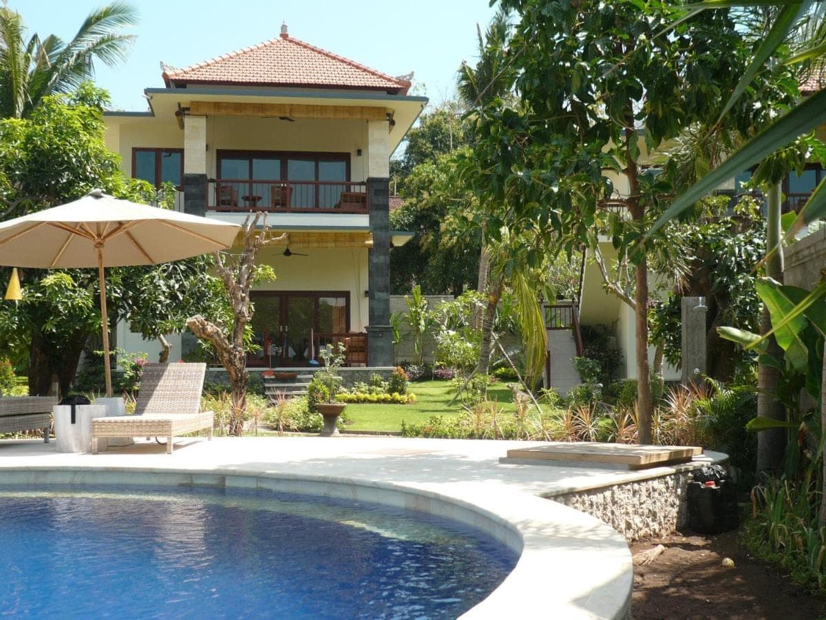 a house with a swimming pool and an umbrella at Sukun Babonsay Villas in Amed