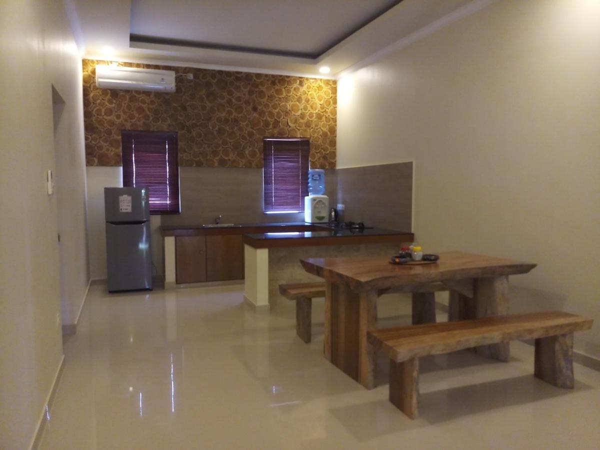 a kitchen with wooden tables and a refrigerator at Sukun Babonsay Villas in Amed
