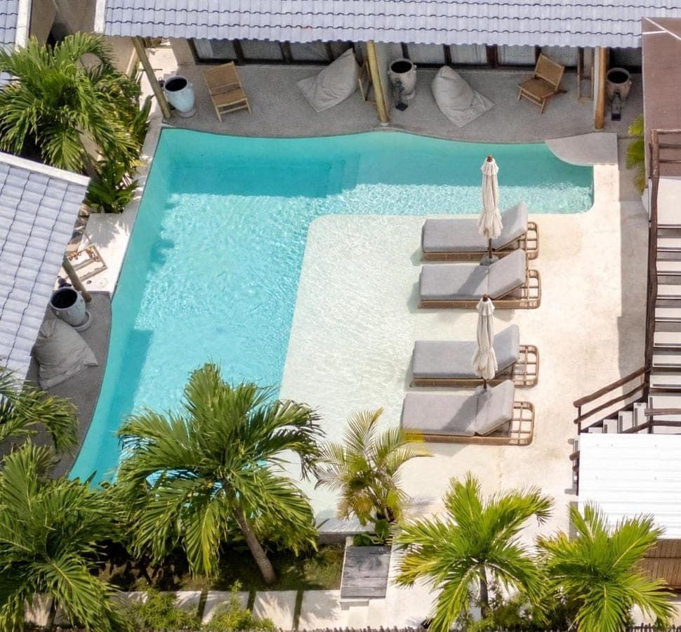 an overhead view of a swimming pool with chaise lounge chairs and a pool at Kano Twin in Canggu