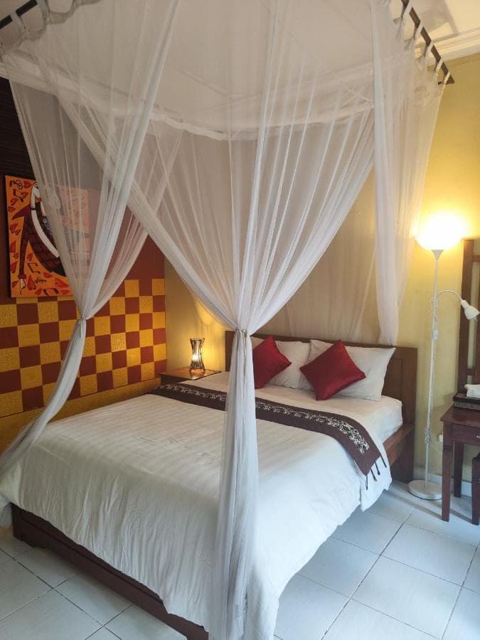a bedroom with a bed with a canopy at Dalum Homestay in Amed