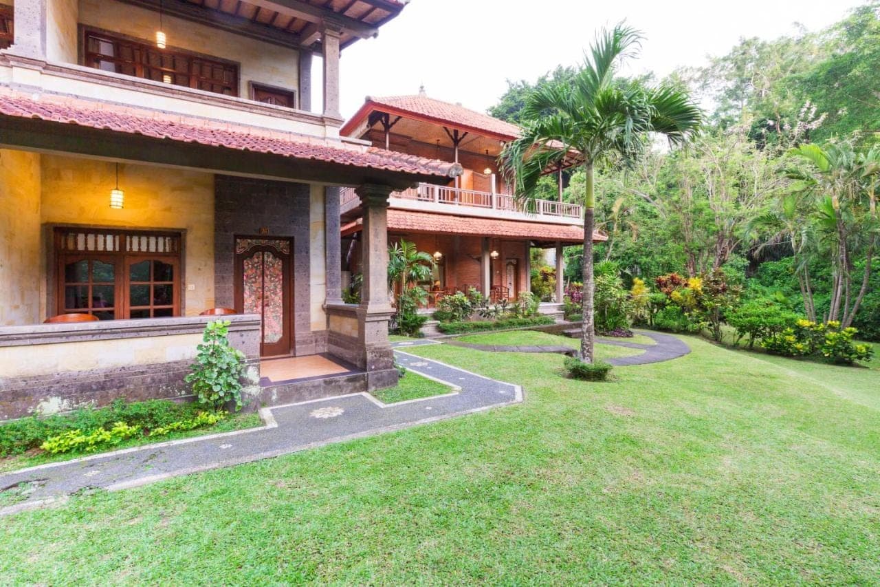 a house with a lawn in front of it at Wenara Bali Bungalows in Ubud