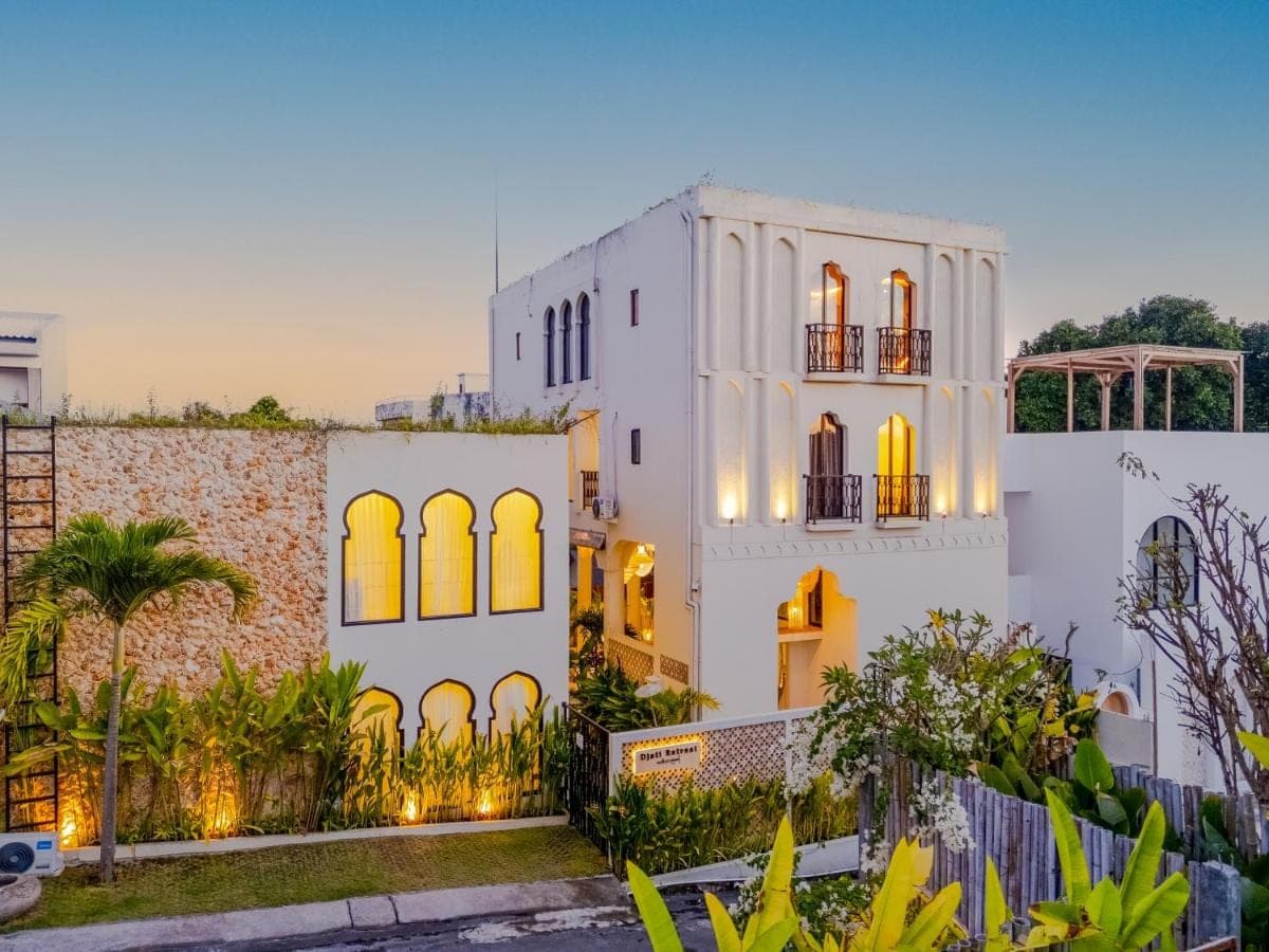 a white house with a fence in front of it at Djati Retreat &amp; Yoga Lounge by Pertama Stay in Nusa Dua
