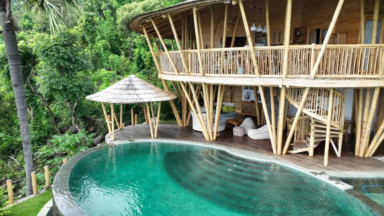 a resort with a swimming pool and a tree house at Villas Bukit Lipah in Amed