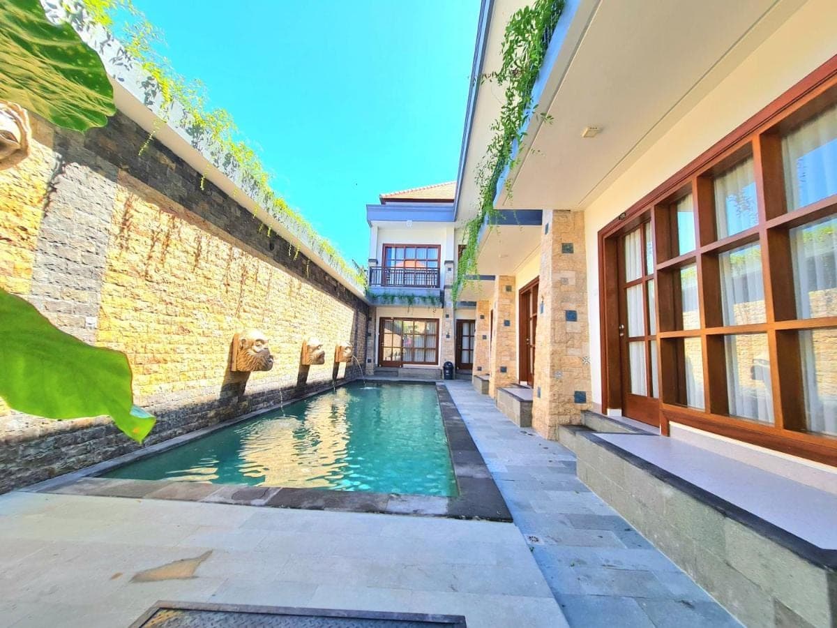 a swimming pool in the middle of a building at Kamandaka Living in Kuta