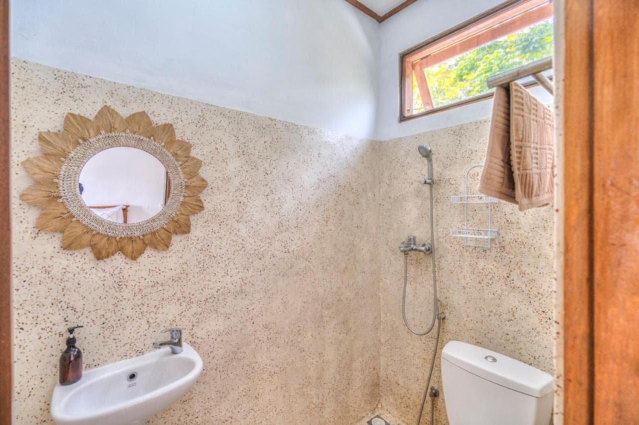 a bathroom with a sink and a mirror at Villa iris Homestay in Uluwatu