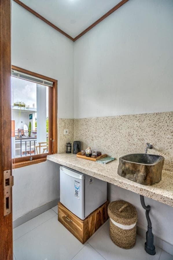 a kitchen with a sink and a counter with a window at Villa iris Homestay in Uluwatu