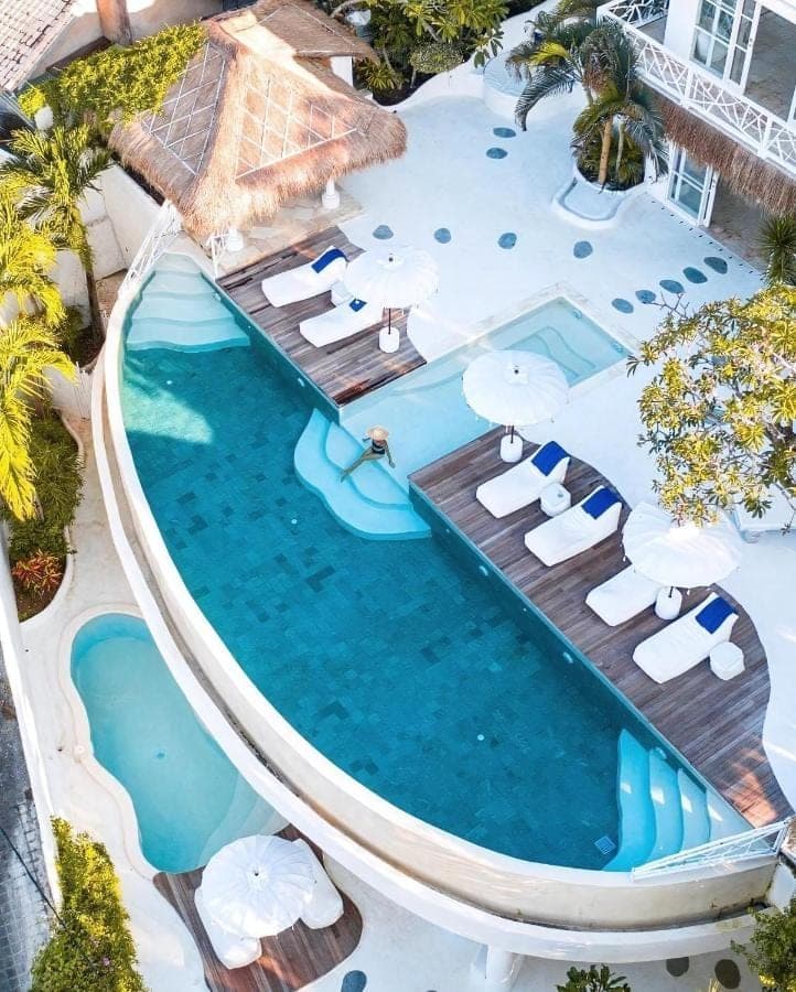an overhead view of a swimming pool with chairs and tables at Gravity Boutique Suites in Uluwatu