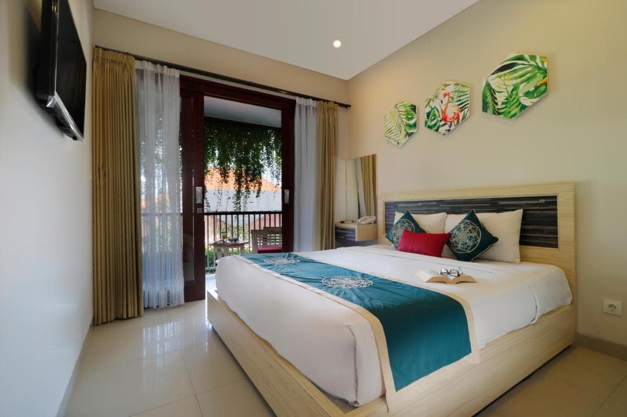 a bedroom with a large bed and a window at Vansari Hotel in Seminyak