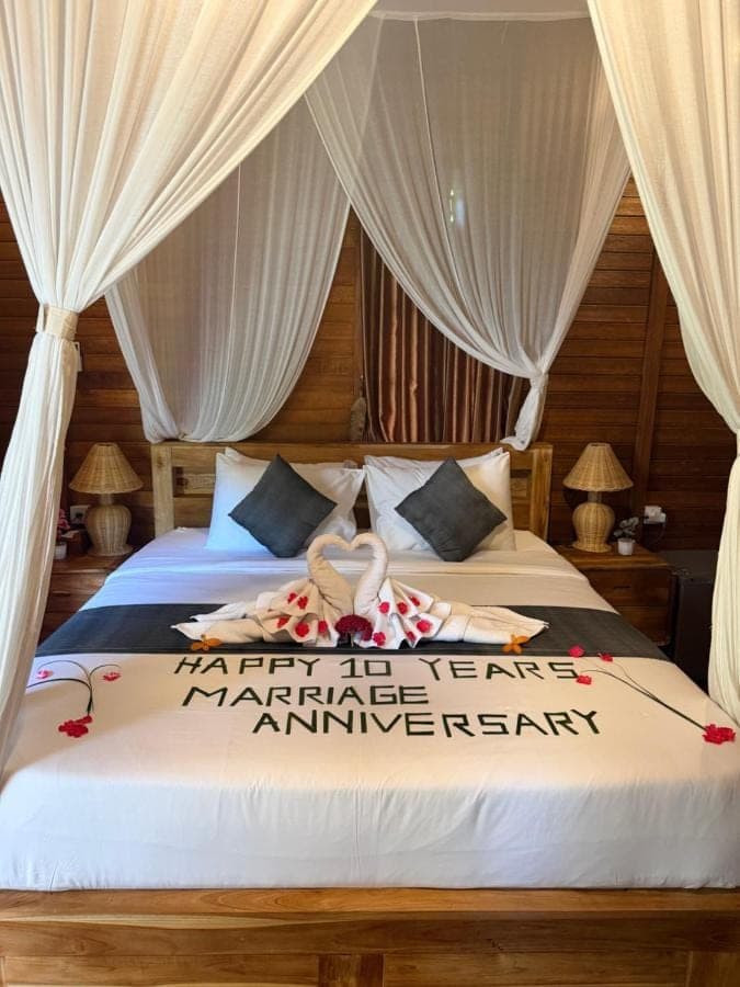 a bedroom with a bed with white drapes at Villas Ume Sedani in Sidemen