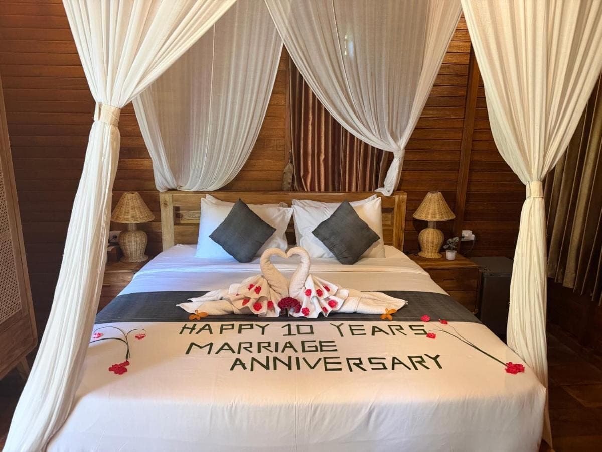 a bed with a happy year marriage anniversary sign on it at Villas Ume Sedani in Sidemen
